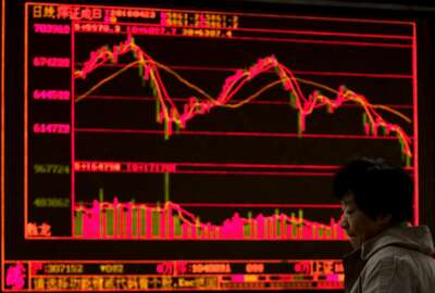 A woman reacts at a brokerage house displaying stock trading index in Beijing, Monday, April 23, 2018. Shares were mostly lower in Asia on Monday following Friday's steep slide in technology shares on Wall Street. Markets had only a muted reaction, if any, to North Korea's announcement that it would stop nuclear and missile testing. (AP Photo/Andy Wong)