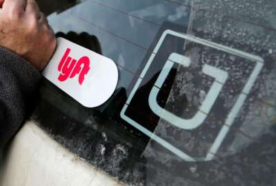 FILE- In this Jan. 31, 2018, file photo, a Lyft logo is installed on a Lyft driver's car next to an Uber sticker in Pittsburgh. Uber and Lyft drivers might seem well-insured, between the ride-booking companies’ coverage and their own policies. However, a crucial gap leaves drivers at risk if they have an accident at the wrong time. (AP Photo/Gene J. Puskar, File)