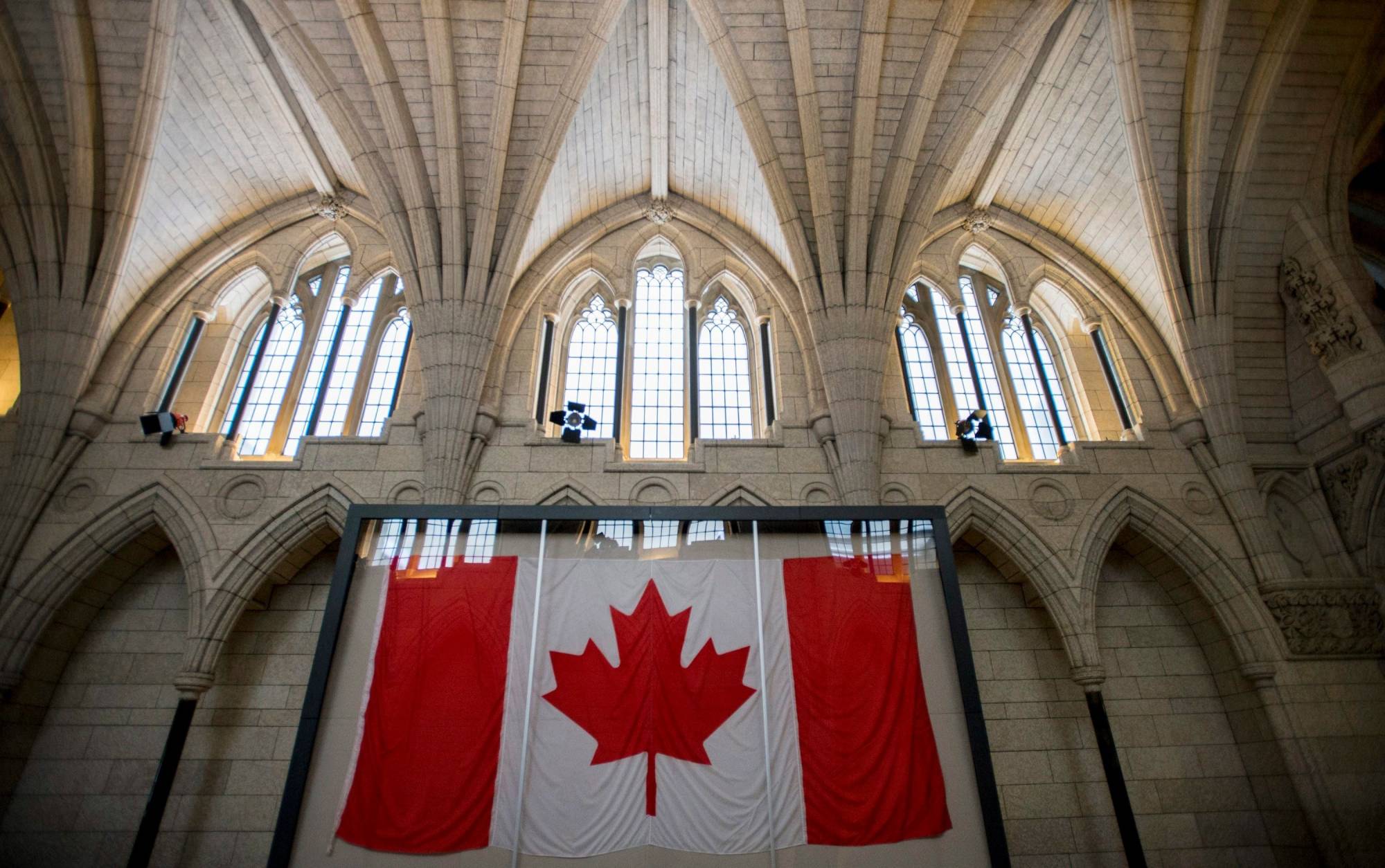 FILE - In this Feb. 14, 2015, file photo, the Maple Leaf flag believed to be the one to be first raised above the Peace Tower on Feb. 15, 1965, following resolution and creation of a distinctive Canadian flag, is seen in a display case in the Hall of Honour on Parliament Hill in Ottawa, Ontario. An online story falsely claims Canadians now can be jailed simply for using an incorrect gender pronoun. The article posted to The Daily Signal website said a law enacted in 2017 would lead to hate crime charges against people who use an incorrect pronoun to describe a transgender person. (Justin Tang/The Canadian Press via AP, File)