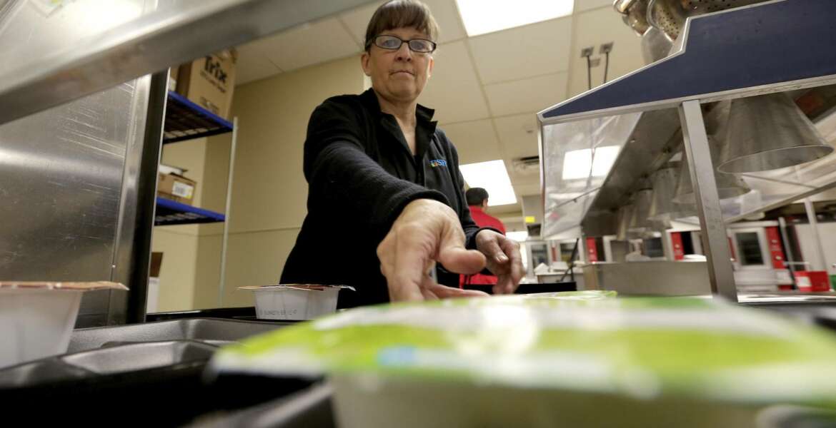 A kitchen server places breakfast out in an empty cafeteria at Kyrene De Las Lomas Elementary School Thursday, April 26, 2018, in Phoenix. Teachers in Arizona and Colorado walked out of their classes over low salaries keeping hundreds of thousands of students out of school. It's the latest in a series of strikes across the nation over low teacher pay. (AP Photo/Matt York)