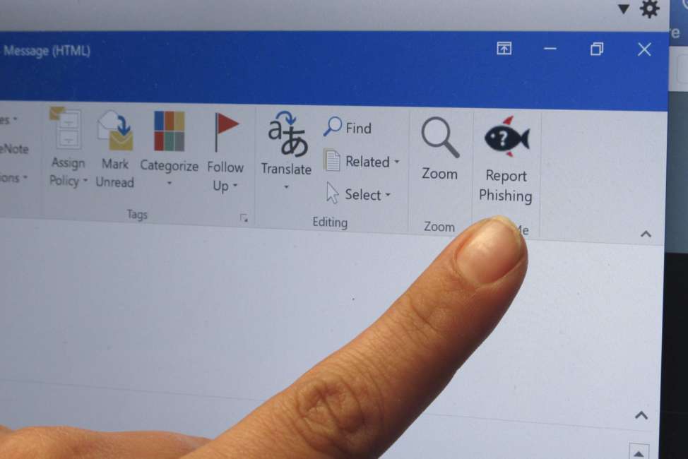 A security analyst points to a button that Ohio State University email users can click to report suspected phishing messages, Friday, March 30, 2018 in Columbus. Ohio State is among schools using fake phishing messages to make students and employees more alert and adept at spotting real cybersecurity threats. (AP Photo/Kantele Franko)