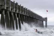 A surfer makes his way out into the water as a subtropical approaches on Monday, May 28, 2018, in Pensacola, Fla. The storm gained the early jump on the 2018 hurricane season as it headed toward anticipated landfall sometime Monday on the northern Gulf Coast, where white sandy beaches emptied of their usual Memorial Day crowds. (AP Photo/Dan Anderson)