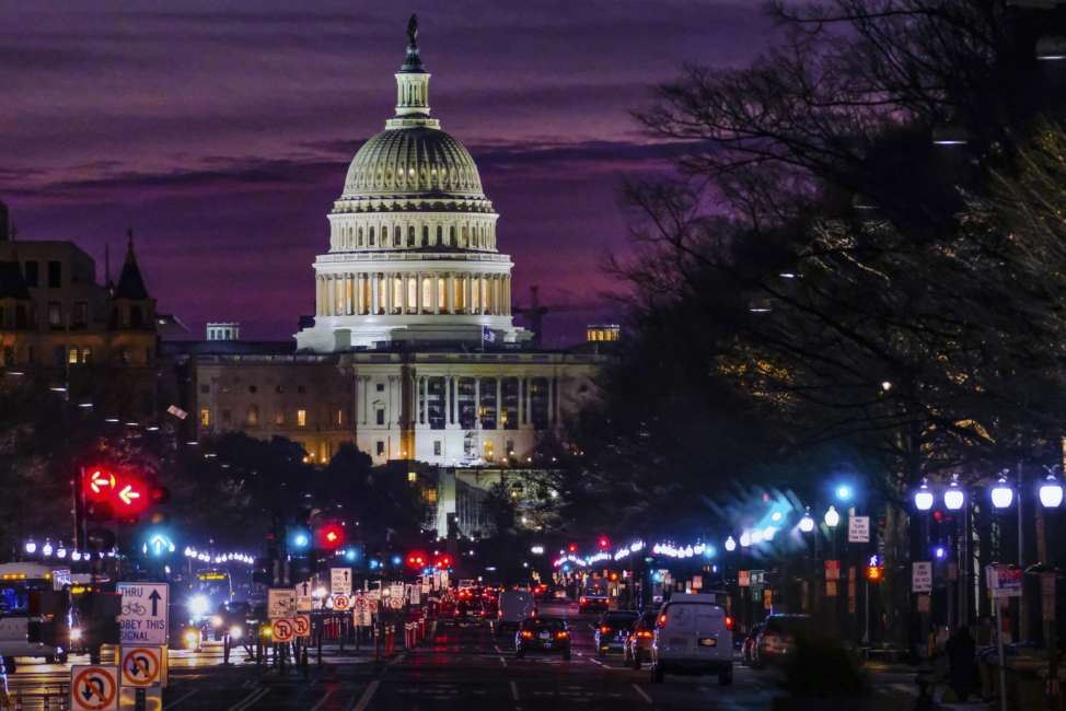 FILE - In Dec. 14, 2016 file photo, early morning traffic rolls down Pennsylvania Avenue toward the U.S. Capitol as daybreaks in Washington.   The federal government swung to a surplus of $214.3 billion in April, 2018 primarily reflecting the revenue from that month’s annual tax filing deadline. The Treasury Department reports that last month’s surplus increased 17.4 percent from a year ago. (AP Photo/J. David Ake, File)