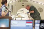 FILE - In this June 3, 2010, file photo, Dr. Steven Birnbaum works with a patient in a CT scanner at Southern New Hampshire Medical Center in Nashua, N.H. According to a study released on Wednesday, May 16, 2018, less than 2 percent of eligible current and former smokers have sought free lung cancer screening, five years after government and private insurers started paying for it. (AP Photo/Jim Cole, File)