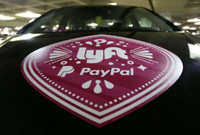 FILE - In this March 31, 2016, a Lyft ride-hailing service logo is displayed on a vehicle at Seattle-Tacoma International Airport in Seattle. A federal appeals court has reinstated a challenge to Seattle's first-in-the-nation law allowing drivers of ride-hailing companies such as Uber and Lyft to unionize. (AP Photo/Ted S. Warren, File)