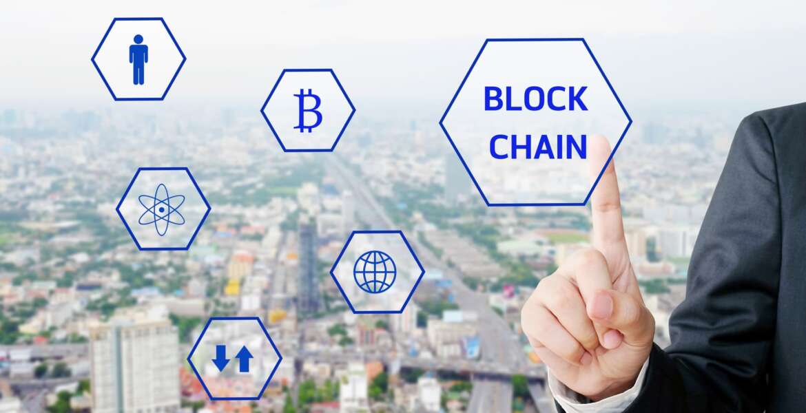 Businessman hand touching block chain icon over blur city background, cryptocurrency, bitcoin concept