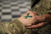 U.S. Army Sgt. 1st Class Tyrone Lawrence, right, places a temporary teal ribbon tattoo on a Soldier's hand at the Koele dining facility at Bagram Airfield in Parwan province, Afghanistan, April 2, 2014. The teal ribbon was the symbol of sexual assault survivors and awareness. (DoD photo by Staff Sgt. Kelly Simon, U.S. Army/Released)
