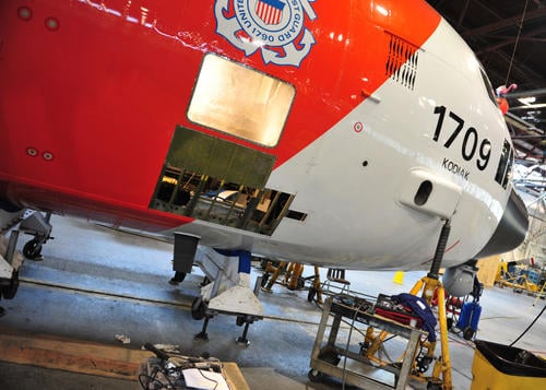 A Coast Guard Air Station Kodiak HC-130 Hercules airplane rests on cradles during a routine maintenance to the skin of the plane. 