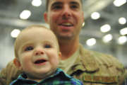 
Aiden Robillard smiles in the arms of his father, Staff Sgt. Tim Robillard, Jan. 12, 2014, at Hurlburt Field, Fla. Robillard was met by his wife and son after returning home from deployment. Robillard is a 801st Special Operations Aircraft Maintenance Squadron electric and environmental systems maintainer. (U.S. Air Force photo by Staff Sgt. John Bainter/Released)