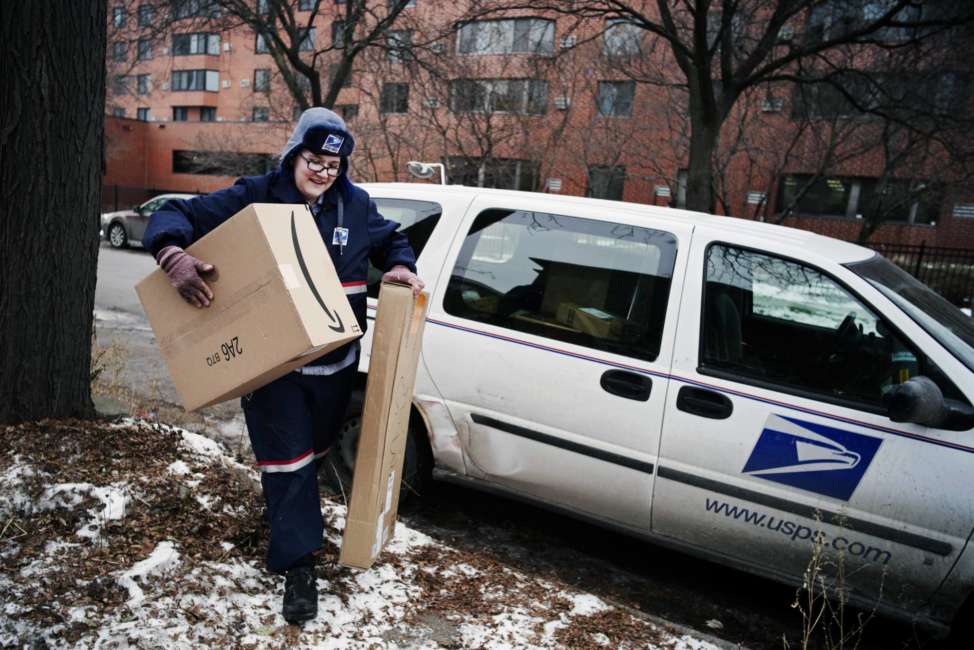 FILE- In this Dec. 24, 2017, file photo, United States Postal Service worker Missie Kittok, who has been a letter carrier for 15 months, helps deliver some packages in time for Christmas in Minneapolis, Amazon’s Prime shipping program set the pace for shoppers’ expectations, and the nation’s largest online player continues to look for new ways to keep up with shoppers’ demands. That’s forcing other companies to radically think of new initiatives to get products to shoppers’ doors faster. (Richard Tsong-Taatarii/Star Tribune via AP, File)