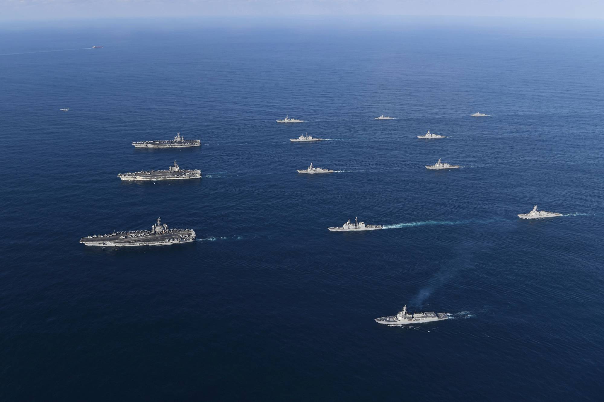FILE - In this Nov. 12, 2017, file photo provided by South Korea Defense Ministry, three U.S. aircraft carriers USS Nimitz, left top, USS Ronald Reagan, left center, and USS Theodore Roosevelt, left bottom, participate with other U.S. and South Korean navy ships during a joint naval exercises between the United States and South Korea in waters off South Korea's eastern coast. U.S. President Donald Trump promised to end “war games” with South Korea, calling them provocative, after meeting North Korean leader Kim Jong Un on June 12, 2018. His announcement appeared to catch both South Korea and the Pentagon by surprise. (South Korea Defense Ministry via AP, File)