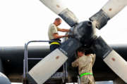 U.S. Air Force Tech. Sgt. Christopher Chadwell, left, performs a propeller hydraulic fluid level check while Staff Sgt. William Aker does an engine inlet inspection on a C-130E Hercules aircraft at an undisclosed location in Southwest Asia Aug.11, 2010. Both Airmen are assigned to the 386th Expeditionary Maintenance Group. (DoD photo by Senior Airman Laura Turner, U.S. Air Force/Released)