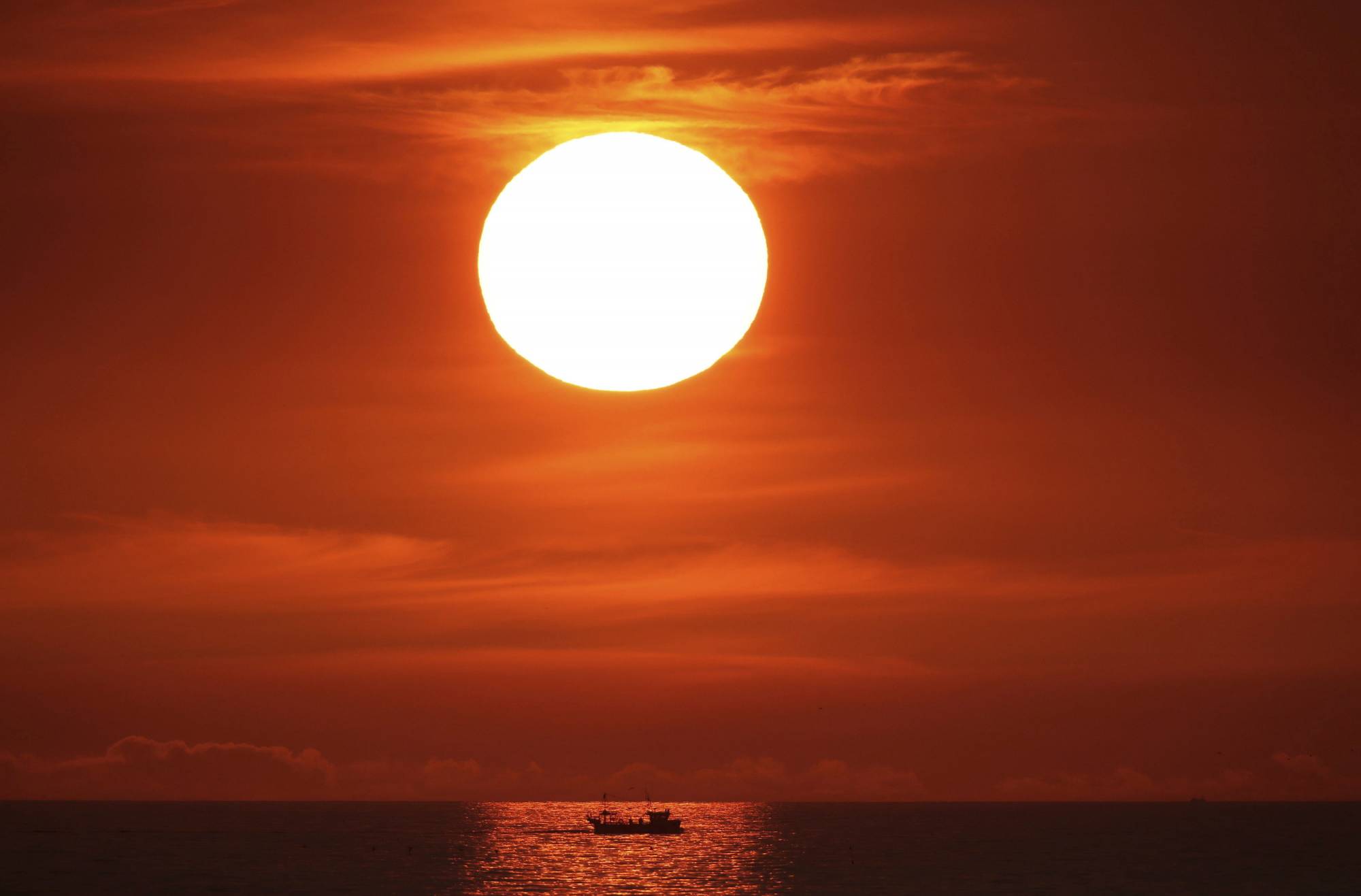 The sun rises at Cullercoats Bay on Engalnd's north east coast, Thursday July 26, 2018. Temperatures are expected to hit 35C (95 Fahrenheit) today as the heatwave continues across the UK. (Owen Humphreys/PA via AP)