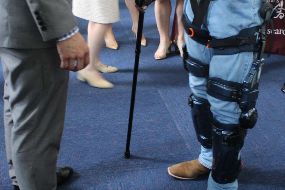 Navy veteran Joseph Bailey Jr., right, tests out the Keeogo exoskeleton, a pair of robotic prosthetics to make him more abulatory, at the VA Research Fair on June 9, 2018.