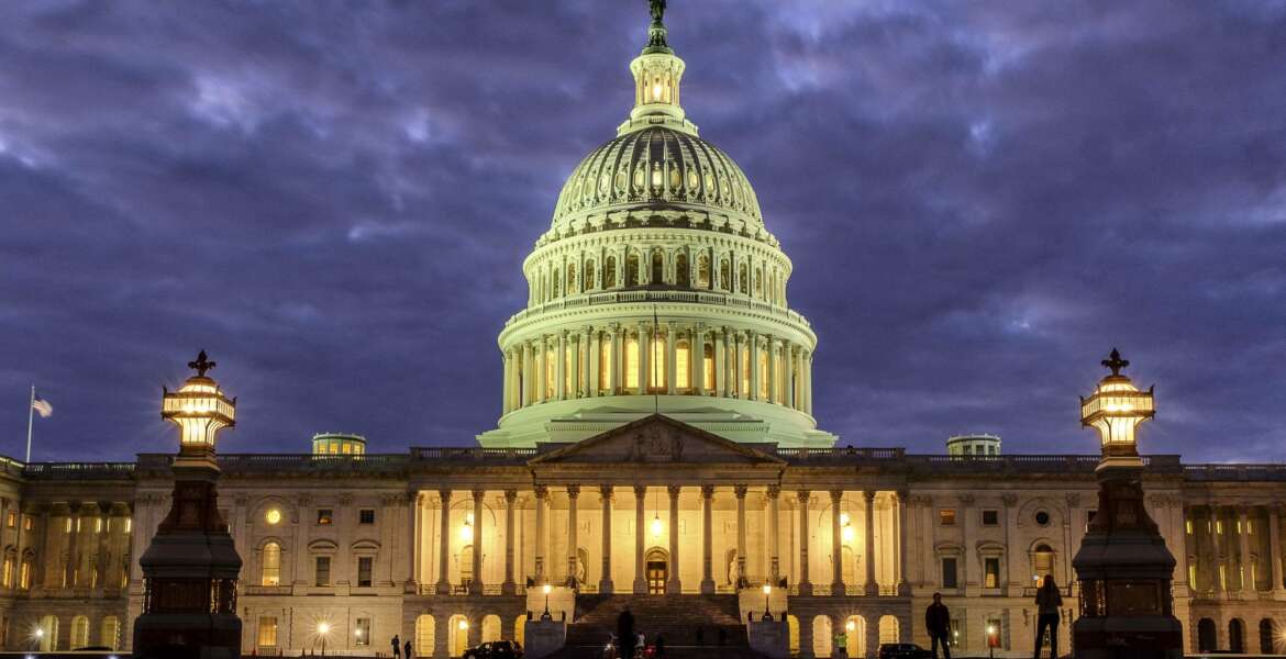 FILE - In this Jan. 21, 2018 file photo, lights shine inside the U.S. Capitol Building as night falls in Washington. Dozens of web addresses implying U.S. senators were “for sale” have been quietly and mysteriously purchased online, amid heightened concerns on Capitol Hill that foreign agents _ especially Russians _ might be trying to interfere in the upcoming midterm elections. The Associated Press has determined that Democrats were responsible. The cybersecurity director for the sergeant-at-arms in the Senate has begun to look into the matter.   (AP Photo/J. David Ake)