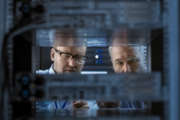 Two Server Engineers Install Hardware in Server Rack. They Work in Big Modern Data Center.