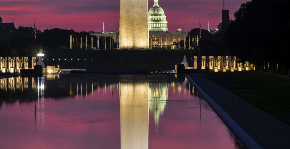 The U.S. Capitol and the base of the Washington Monument are mirrored in the reflecting pool on the National Mall at sunrise in Washington, Saturday, Aug. 25, 2018. (AP Photo/J. David Ake)