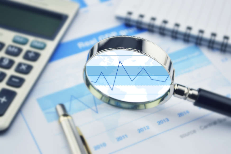 Magnifying glass, calculator and pen on financial graph, growth concept