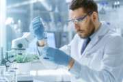 In a Modern Laboratory Scientist Conducts Experiments by Synthesising Compounds with use of Dropper and Plant in a Test Tube.