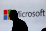 FILE - In this Nov. 7, 2017, file photo, a man is silhouetted as he walks in front of Microsoft logo at an event in New Delhi, India. Microsoft says it’s uncovered new Russian hacking attempts targeting U.S. political groups ahead of the midterm elections. The company said Tuesday, Aug. 21, 2018, that a hacking group tied to the Russian government created fake internet domains that appeared to spoof two conservative organizations: the Hudson Institute and the International Republican Institute. (AP Photo/Altaf Qadri, File)