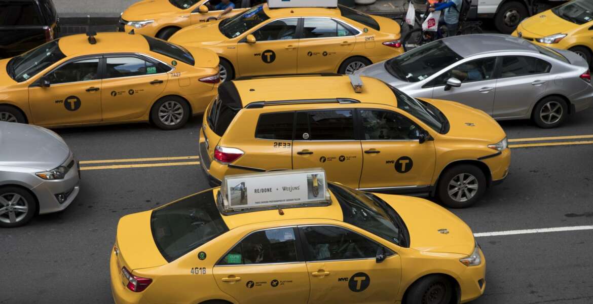 In this Wednesday, Aug. 1, 2018 photo, yellow cabs make their way across 42nd Street outside Grand Central Terminal in New York. Responding to tales of financial woe, New York City lawmakers are considering a proposal to try and stabilize the city's iconic taxi industry by putting a temporary cap on the number of drivers working for companies like Uber and Lyft. The restrictions come after a year in which many drivers for-hire in the city have complained that the explosion in the popularity of ride-hailing services has upended regulations intended to limit competition and ensure that every driver made enough money to survive. (AP Photo/Mary Altaffer)