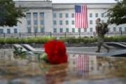 A member of the military walks the grounds of the National 9/11 Pentagon Memorial before the start of the September 11th Pentagon Memorial Observance at the Pentagon on the 17th anniversary of the September 11th attacks, Tuesday, Sept. 11, 2018. (AP Photo/Pablo Martinez Monsivais)