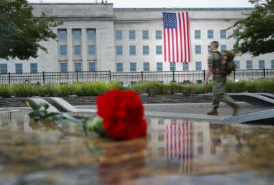 A member of the military walks the grounds of the National 9/11 Pentagon Memorial before the start of the September 11th Pentagon Memorial Observance at the Pentagon on the 17th anniversary of the September 11th attacks, Tuesday, Sept. 11, 2018. (AP Photo/Pablo Martinez Monsivais)