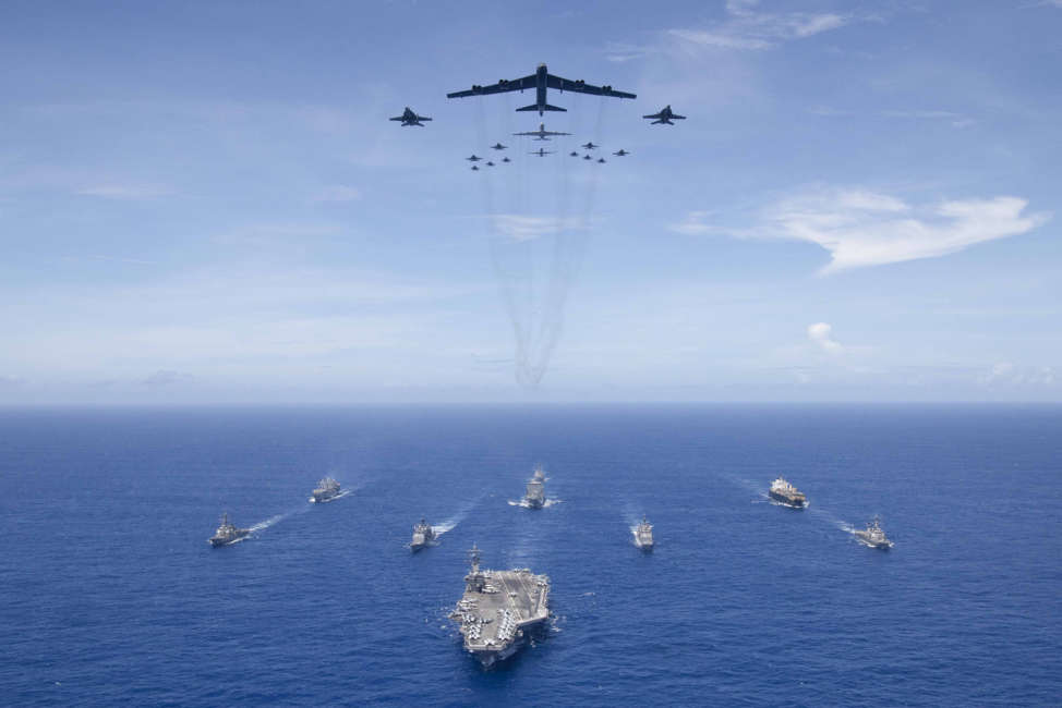 PHILIPPINE SEA (Sept. 17, 2018) The aircraft carrier USS Ronald Reagan (CVN 76) leads a formation of Carrier Strike Group (CSG) 5 ships as U.S. Air Force B-52 Stratofortress aircraft and U.S. Navy F/A-18 Hornets pass overhead for a photo exercise during Valiant Shield 2018. The biennial, U.S. only, field-training exercise focuses on integration of joint training among the U.S. Navy, Air Force and Marine Corps.