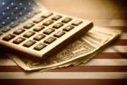 Calculator, dollars and USA flag. Sepia image.