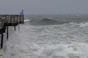 An onlooker checks out the heavy surf at the Avalon Fishing Pier in Kill Devil Hills, N.C., Thursday, Sept. 13, 2018 as Hurricane Florence approaches the east coast. (AP Photo/Gerry Broome, File)