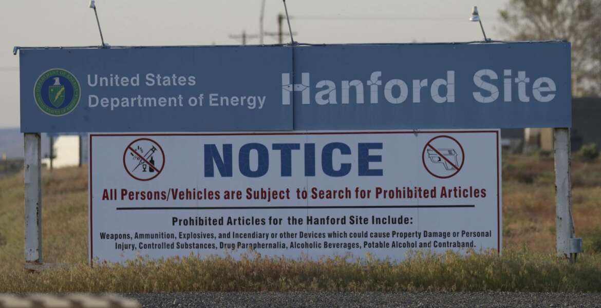 FILE - In this May 9, 2017, file photo, signs are posted by the Hanford Nuclear Reservation in Benton County in Richland, Wash. The U.S. government will pay $925,000 and improve worker safety to settle a lawsuit over employee exposure to chemical vapors at the nation's most polluted nuclear weapons production site. Washington state Attorney General Bob Ferguson said Wednesday, Sept. 19, 2018, that the U.S. Energy Department will test new technology to capture and destroy dangerous vapors that escape from nuclear waste storage tanks at Hanford Nuclear Reservation. (AP Photo/Manuel Valdes, File)