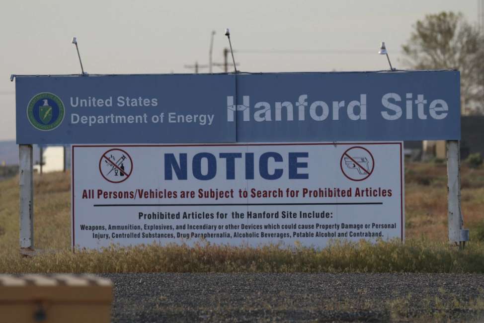 FILE - In this May 9, 2017, file photo, signs are posted by the Hanford Nuclear Reservation in Benton County in Richland, Wash. The U.S. government will pay $925,000 and improve worker safety to settle a lawsuit over employee exposure to chemical vapors at the nation's most polluted nuclear weapons production site. Washington state Attorney General Bob Ferguson said Wednesday, Sept. 19, 2018, that the U.S. Energy Department will test new technology to capture and destroy dangerous vapors that escape from nuclear waste storage tanks at Hanford Nuclear Reservation. (AP Photo/Manuel Valdes, File)