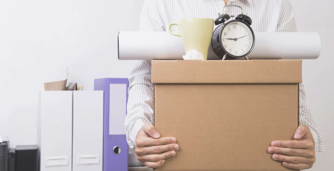 businessman holding personal items box ready moving leaving company. concept layoffs.