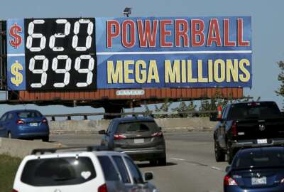 In this Monday, Oct. 22, 2018 photo, drivers on the Broken Arrow Expressway pass a sign with the Powerball and Mega Millions jackpot numbers as they drive toward downtown Tulsa, Okla., Monday, October 22, 2018. (John Clanton/Tulsa World via AP)