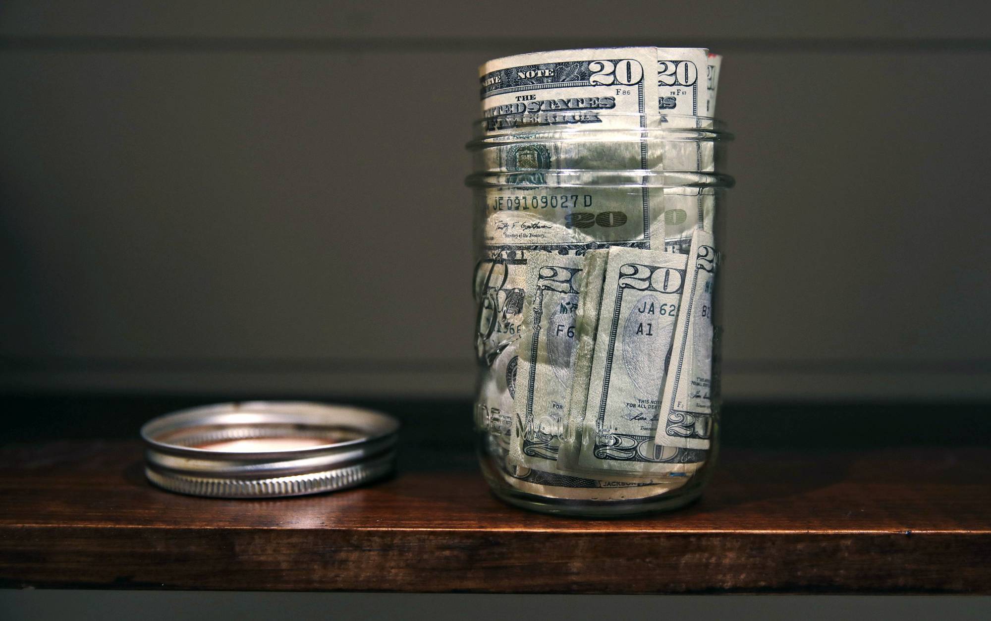 FILE - In this June 15, 2018, file photo a canning jar filled with currency sits on a shelf in East Derry, N.H. The idea of having enough money to hire a financial adviser seems like a dream for many. Fortunately, there are less expensive, even free, ways to take a do-it-yourself approach to managing and growing your money. (AP Photo/Charles Krupa, File)