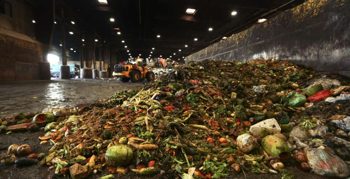 In this Aug. 29, 2018, photo, at the Waste Management facility in North Brooklyn, tons of leftover food sits piled up before being processed into 
