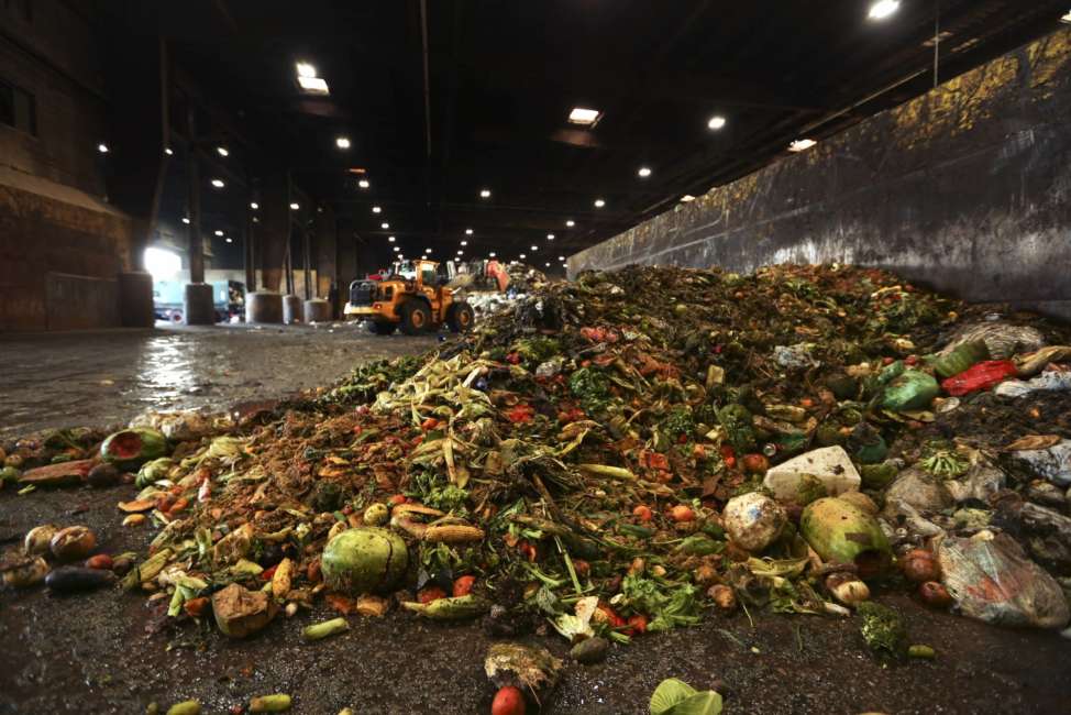 In this Aug. 29, 2018, photo, at the Waste Management facility in North Brooklyn, tons of leftover food sits piled up before being processed into "bio-slurry," in New York. The "bio-slurry" can be turned into methane gas at a nearby wastewater treatment plant. (AP Photo/Stephen Groves)