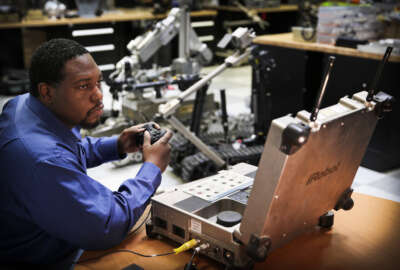 James Hopkins, a D Department robotics engineer at NSWC IHEODTD, evaluates the external battery adapter for the MK 1 Mod 0 PackBot's operator control station.  U.S. Navy photos by Matthew Poynor.
