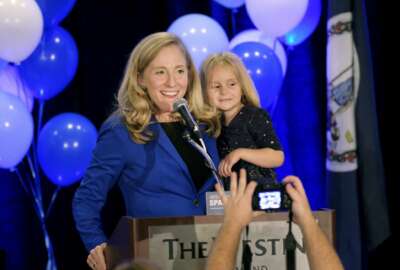Democrat Abigail Spanberger claims victory in the 7th district Virginia congressional race while holding her daughter Catherine, 4, during a victory party in Richmond, Va., late Tuesday, Nov. 6, 2018. She defeated two-term Republican congressman Dave Brat. (Dean Hoffmeyer/Richmond Times-Dispatch via AP)
