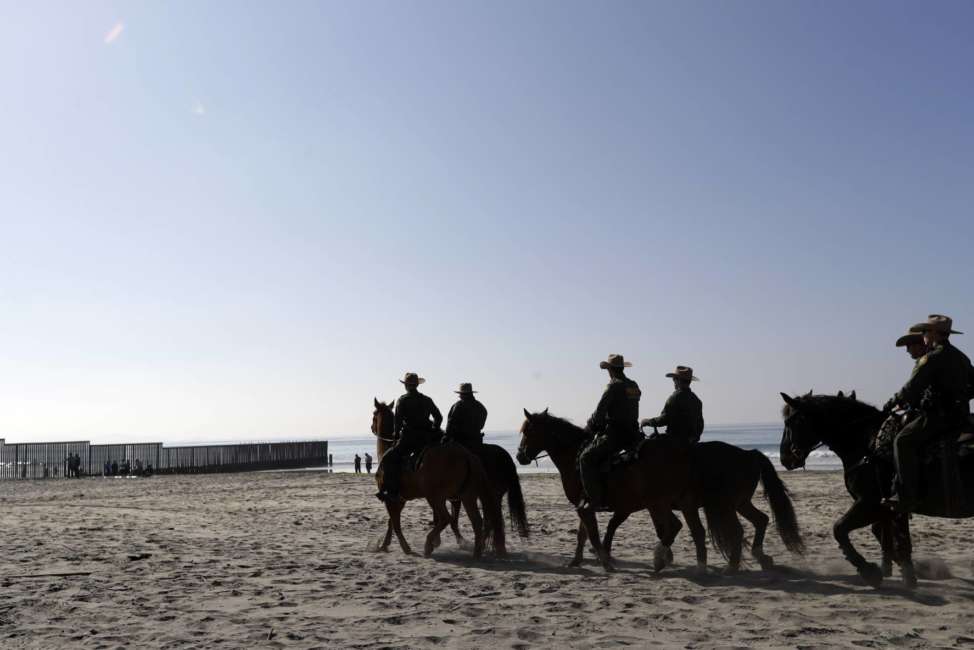 United States Border Patrol agents mounted on horseback ride near the border with Tijuana, Mexico, before a visit by Secretary of Homeland Security Kirstjen Nielsen Tuesday, Nov. 20, 2018, in San Diego. Nielsen said Tuesday an appeal will be filed on the decision by a judge to bar the Trump administration from refusing asylum to migrants who cross the southern border illegally. (AP Photo/Gregory Bull)