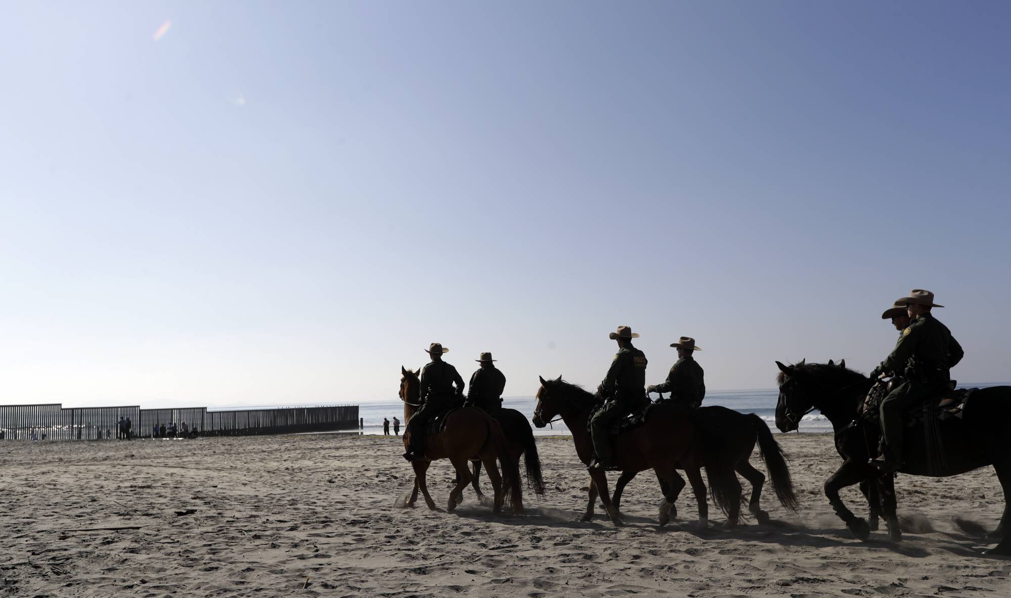United States Border Patrol agents mounted on horseback ride near the border with Tijuana, Mexico, before a visit by Secretary of Homeland Security Kirstjen Nielsen Tuesday, Nov. 20, 2018, in San Diego. Nielsen said Tuesday an appeal will be filed on the decision by a judge to bar the Trump administration from refusing asylum to migrants who cross the southern border illegally. (AP Photo/Gregory Bull)