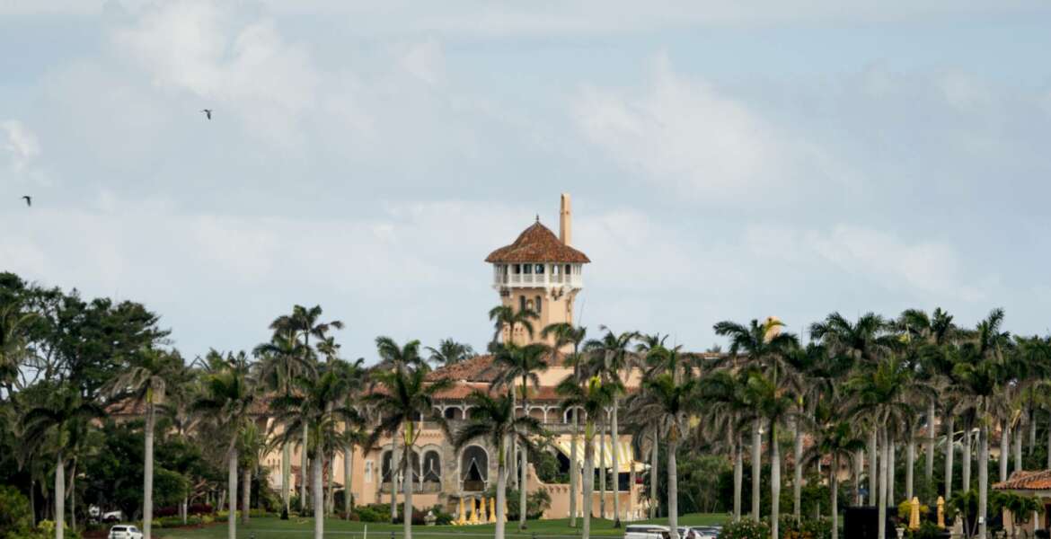FILE - In this Feb. 19, 2018, file photo, Mar-a-Lago is visible from a motorcade carrying President Donald Trump, in Palm Beach, Fla. Trump is making his return to Florida, kicking off the Palm Beach social season at his “winter White House.” All presidents have had their favorite refuges from Washington. But none has drawn the fascination or raised the ethical issues of Mar-a-Lago, where Trump spends his days mixing work, business and play in the company of dues-paying members and staff are on high alert for those seeking influence.(AP Photo/Andrew Harnik, File)