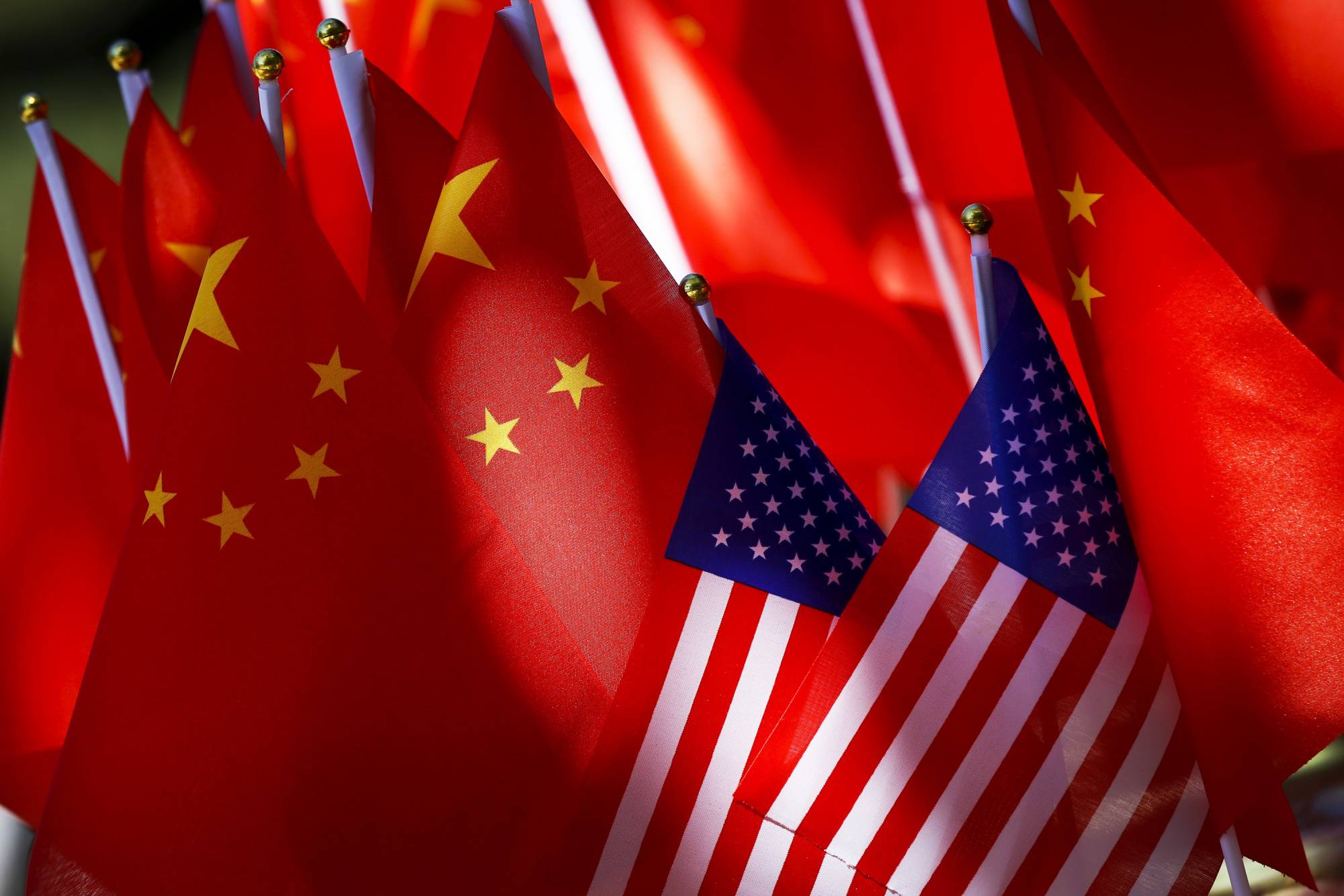 In this Sept. 16, 2018, photo, American flags are displayed together with Chinese flags on top of a trishaw in Beijing.  A congressional advisory panel says the purchase of internet-linked devices manufactured in China leaves the United States vulnerable to security breaches that could put critical U.S. infrastructure at risk. The U.S.-China Economic and Security Review Commission issued the warning Wednesday in a report focused on the increasing use of the internet in household appliances. (AP Photo/Andy Wong)