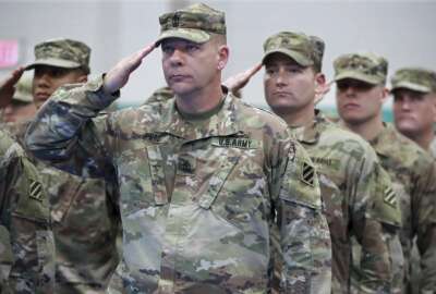First sergeant Archer Ford, from left, sergeant first class Andreson Neal, and members of the Georgia National Guard's 48th Brigade Combat Team salute the colors during the Casing of Color and Departure Ceremony for their deployment to Afghanistan on Friday, Dec 21, 2018, at Fort Stewart. (Curtis Compton/Atlanta Journal-Constitution via AP)