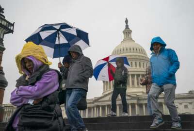 Tourists arrive to visit the U.S. Capitol on a rainy morning in Washington, Friday, Dec. 28, 2018, during a partial government shutdown. The partial government shutdown will almost certainly be handed off to a divided government to solve in the new year, as both parties traded blame Friday and President Donald Trump sought to raise the stakes in the weeklong impasse. (AP Photo/J. Scott Applewhite)