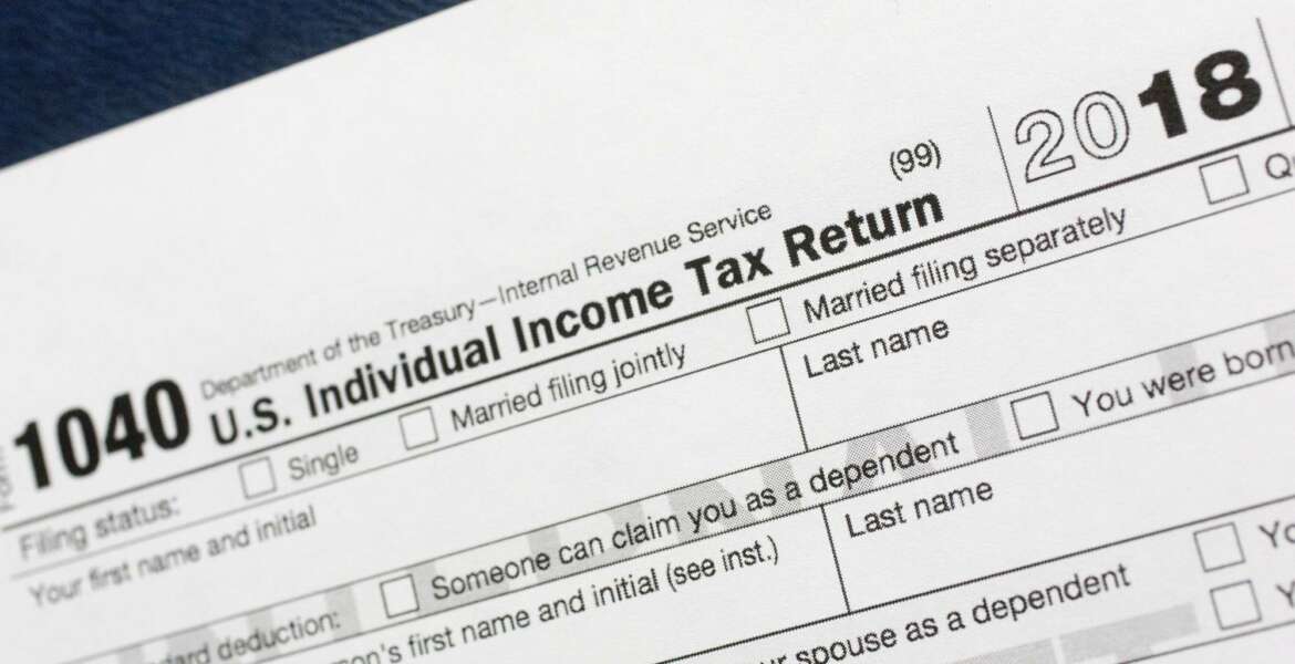 FILE- This July 24, 2018, file photo shows a portion of the 1040 U.S. Individual Income Tax Return form for 2018 in New York. A new rule caps the state and local taxes you can deduct on your federal tax return. That could make more of your income taxable this year, but finding out if the cap affects you, pouncing on other tax breaks, bunching your charitable contributions and planning for a new tax world could help. (AP Photo/Mark Lennihan, File)