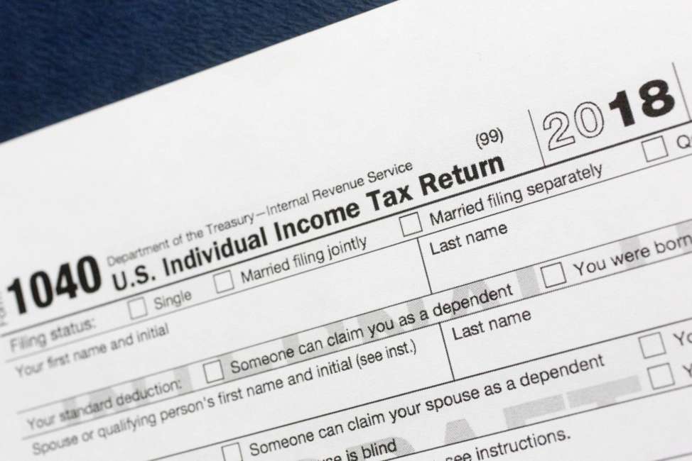 FILE- This July 24, 2018, file photo shows a portion of the 1040 U.S. Individual Income Tax Return form for 2018 in New York. A new rule caps the state and local taxes you can deduct on your federal tax return. That could make more of your income taxable this year, but finding out if the cap affects you, pouncing on other tax breaks, bunching your charitable contributions and planning for a new tax world could help. (AP Photo/Mark Lennihan, File)