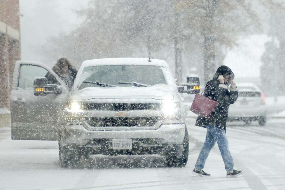 Shoppers walk in a grocery store parking lot in Mechanicsville, Va., on Sunday, December 9, 2018. A wide-reaching winter storm has dumped several inches of snow through North Carolina and Virginia. (Dean Hoffmeyer/Richmond Times-Dispatch via AP)