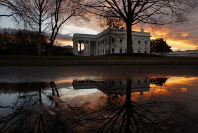 The sun rises behind the White House in Washington, Saturday, Dec. 22, 2018. Hundreds of thousands of federal workers faced a partial government shutdown early Saturday after Democrats refused to meet President Donald Trump's demands for $5 billion to start erecting a border wall with Mexico. Overall, more than 800,000 federal employees would see their jobs disrupted, including more than half who would be forced to continue working without pay. (AP Photo/Carolyn Kaster)
