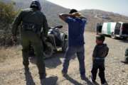 FILE - In this June 28, 2018, file photo, a Guatemalan father and son, who crossed the U.S.-Mexico border illegally, are apprehended by a U.S. Border Patrol agent in San Diego. Children torn from their parents, refugees turned away, tear gas fired on asylum-seekers, and a swath of the globe derided by the president in crude language. In a breathless 2018, they were just a handful of headlines on immigration, one of the year’s most dominant issues. (AP Photo/Jae C. Hong, File)